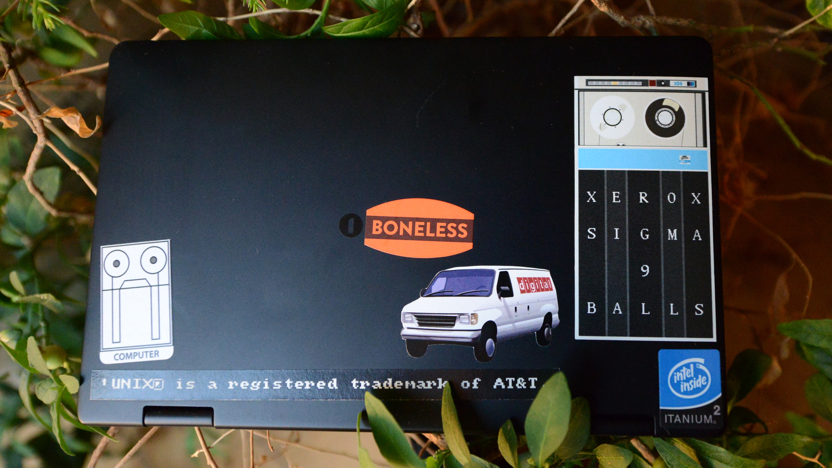 A small black anodised aluminium laptop on a citrus, with the sticker in the middle.